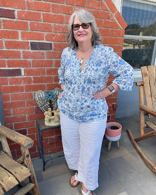 A Blue Floral Blouse, Cropped White Pants, and Silver Jewelry.
